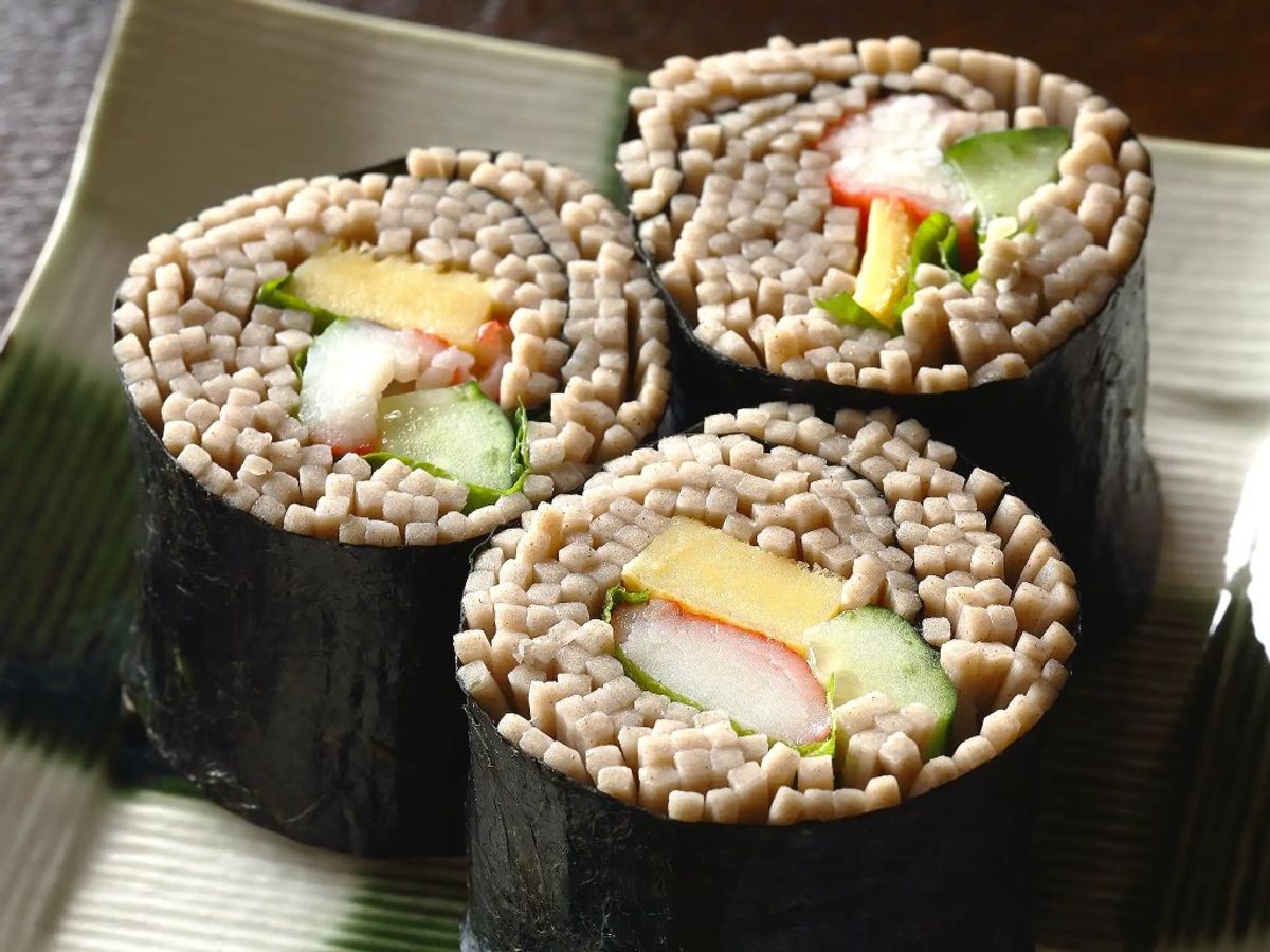 Sushi rolls with sesame seeds, avocado, imitation crab, and cucumber on plate