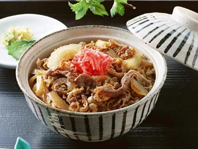 Gyudon beef bowl with sliced beef, onions, pickled ginger in ceramic bowl with lid