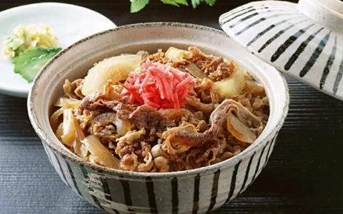 Gyudon beef bowl with sliced beef, onions, pickled ginger in ceramic bowl with lid