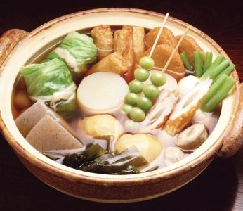 Chanko nabe hot pot with tofu, vegetables, chicken, and broth in earthenware bowl