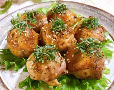 Glazed chicken meatballs garnished with herbs on lettuce bed, plated