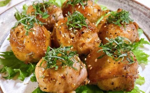 Glazed chicken meatballs garnished with herbs on lettuce bed, plated