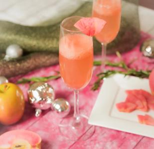 Elegant cocktails with pink flower garnish, festive holiday table setting with ornaments