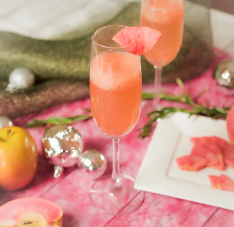 Elegant cocktails with pink flower garnish, festive holiday table setting with ornaments