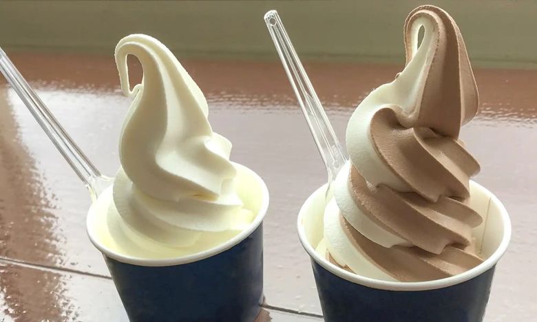 Soft serve ice cream in vanilla and chocolate flavors with spoons in black cups