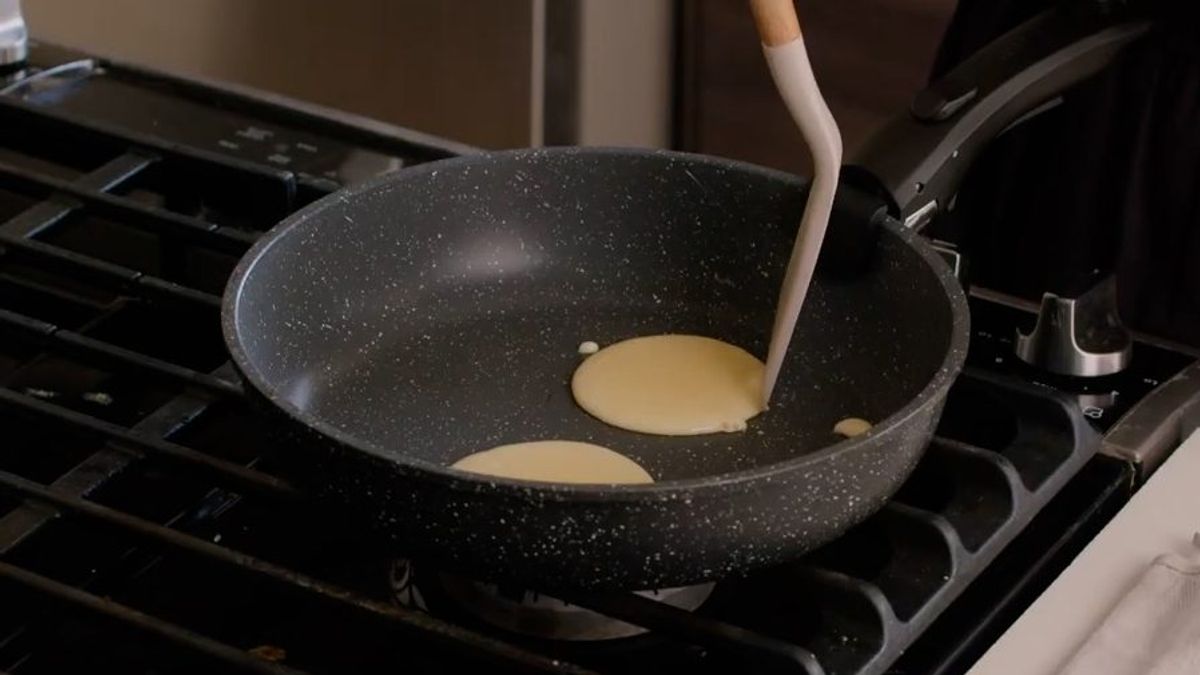 Cooking pancakes in non-stick pan on gas stove burner