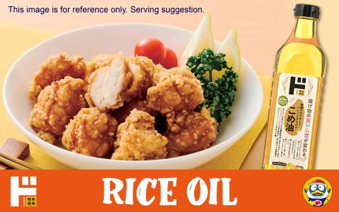 Rice oil bottle next to fried karaage chicken with tomatoes and garnish
