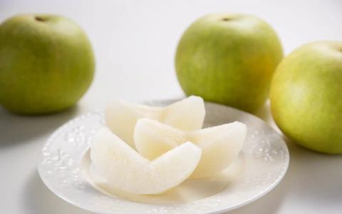 Green apples with sliced apple pieces on white plate