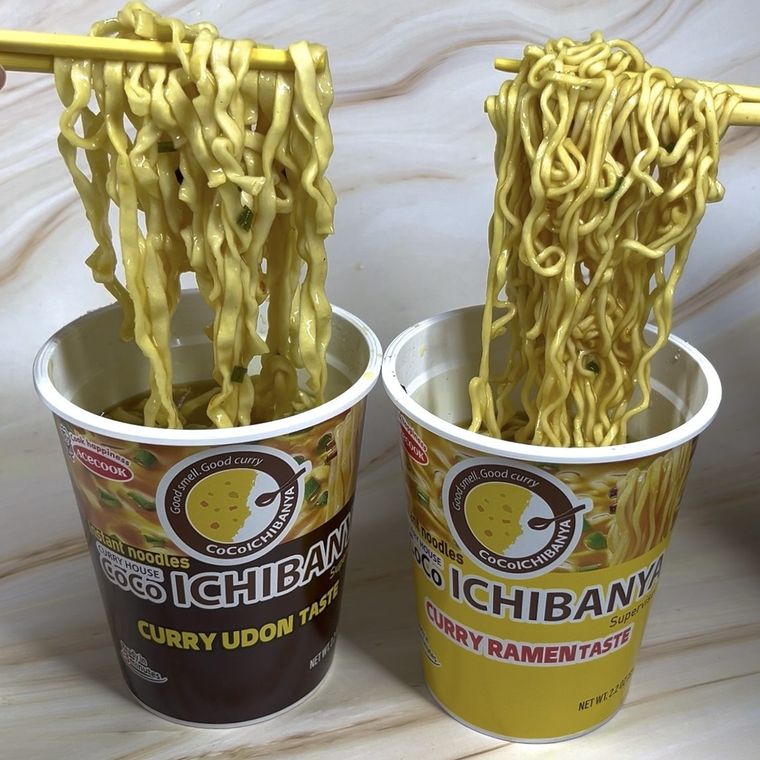 Two Coco Ichibanya instant noodle cups with chopsticks: curry udon and curry ramen flavors