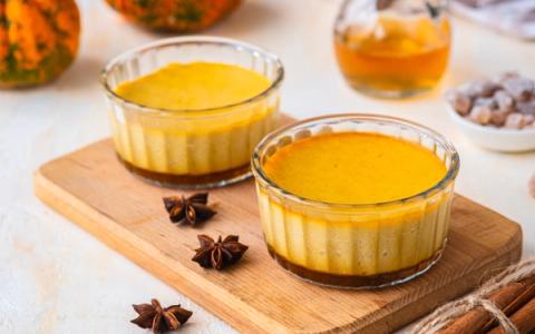 Pumpkin custard desserts in glass ramekins with star anise and cinnamon sticks