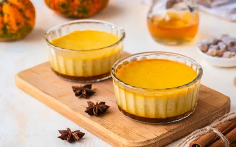 Pumpkin custard desserts in glass ramekins with star anise and cinnamon sticks