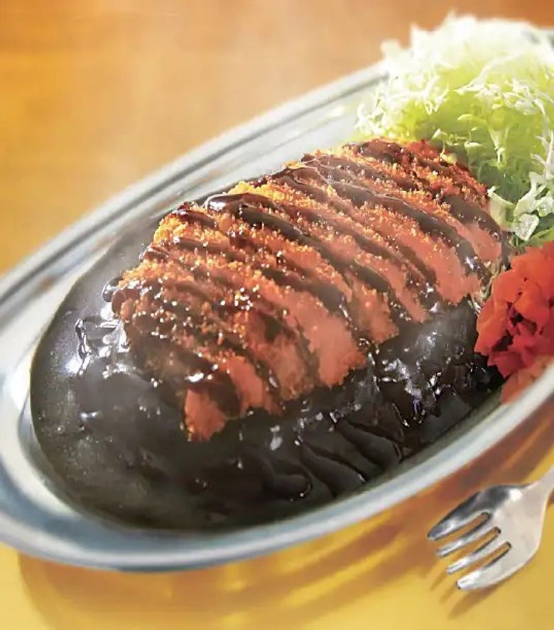 Sliced roasted duck with sesame seeds, shredded lettuce, and pickled ginger on plate