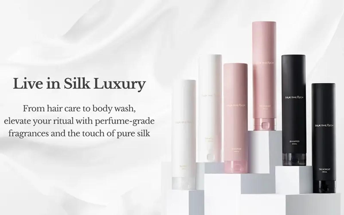 Silk luxury beauty product collection featuring hair care, body wash, and fragrances in white, pink, and black bottles