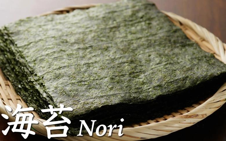 海苔 Nori - 積み重ねた黒い海苔シートが竹ざるの上に置かれている