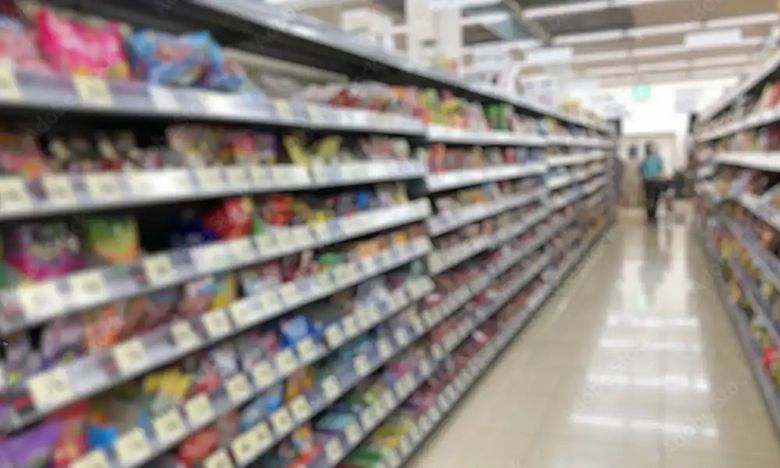 Supermarket aisle with packaged food products on shelves, grocery store interior
