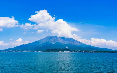 Sakurajima volcano viewed across blue ocean from Kinko Bay, Kagoshima Prefecture Japan