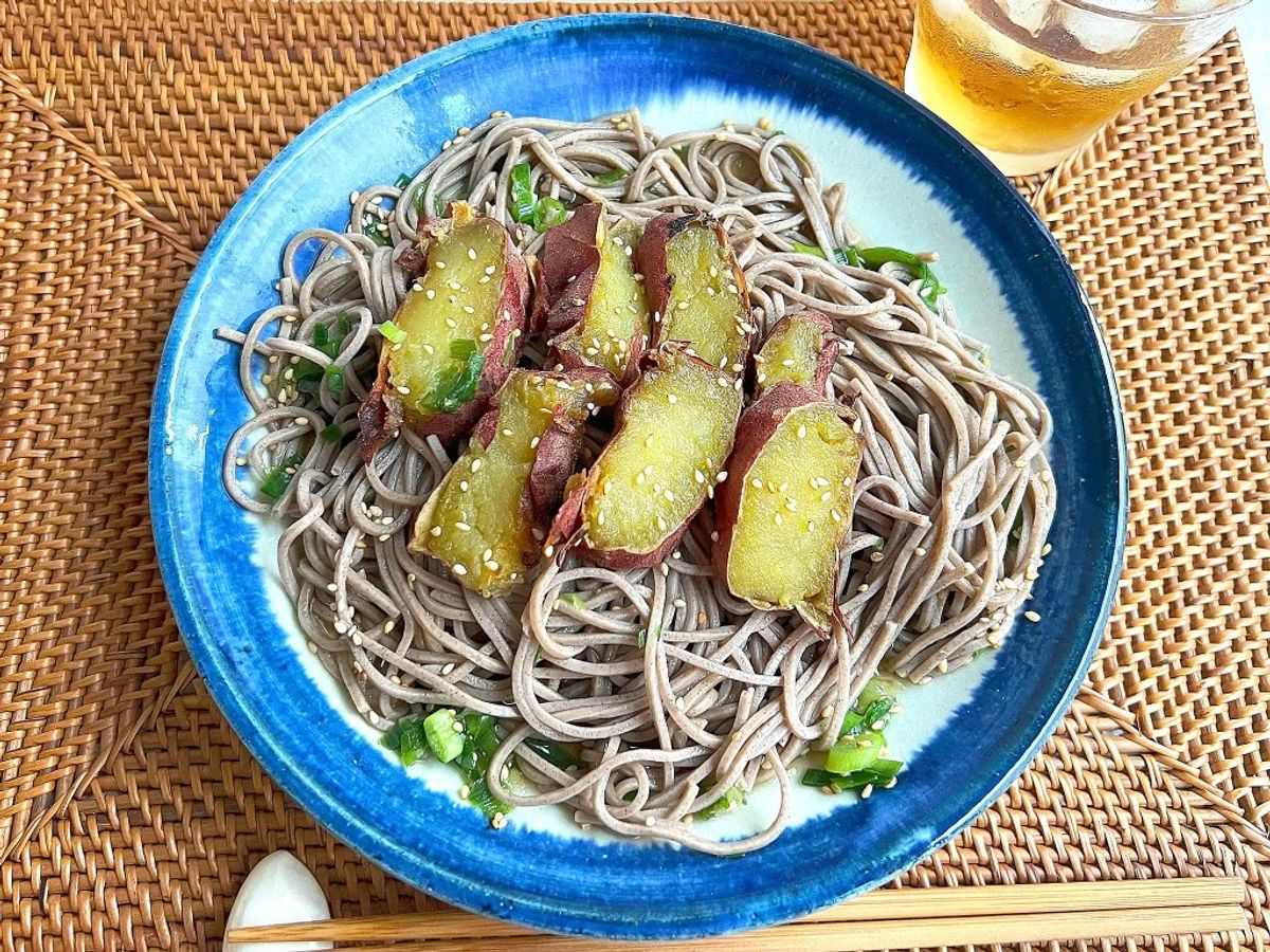 Soba noodles with duck breast, scallions, and ginger in blue bowl