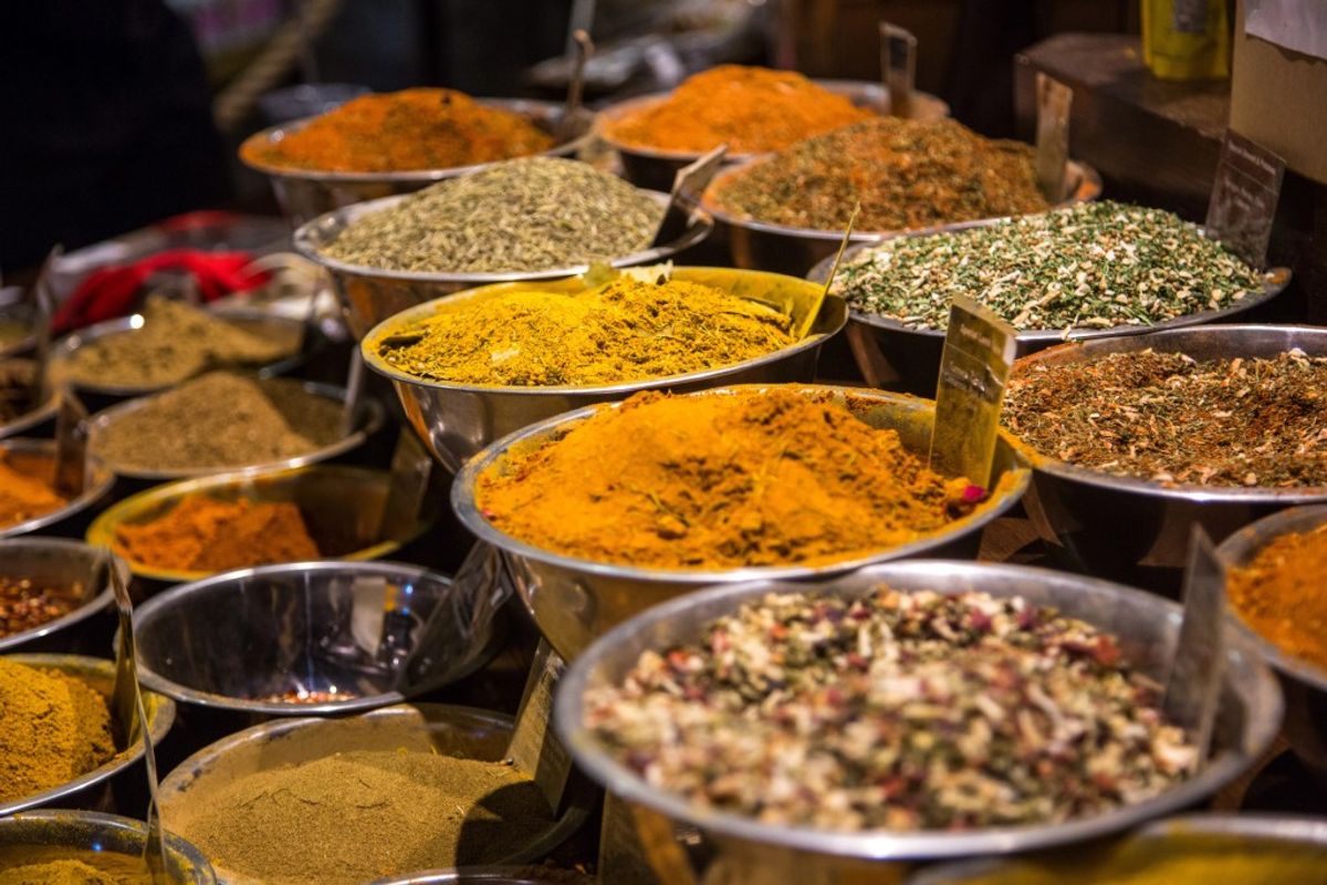 Spice market display with colorful powders and dried herbs in metal bowls