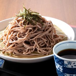 Soba noodles with nori garnish, dipping sauce, and bamboo mat presentation