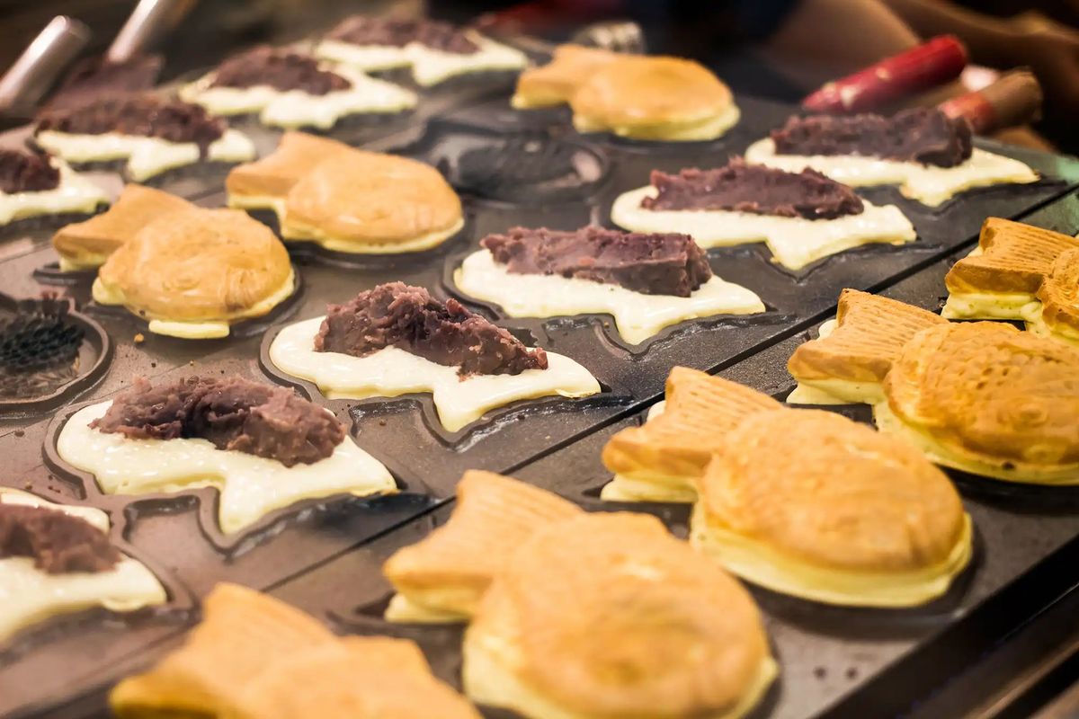Cream puffs and chocolate eclairs arranged on pastry mold for baking