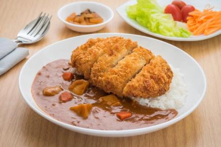 Breaded fried cutlet with creamy sauce, mashed potatoes, and vegetable garnish