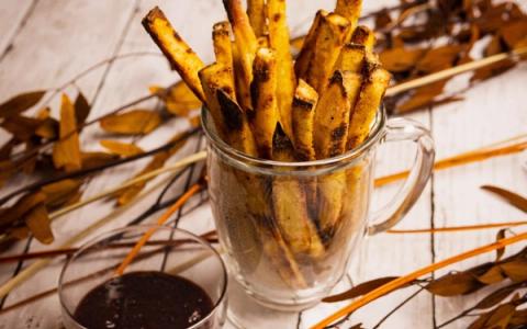 Golden crispy fries in glass mug with dipping sauce and dried seaweed garnish