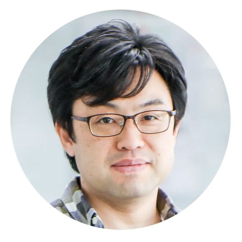 Professional headshot of Asian man wearing glasses and checkered shirt