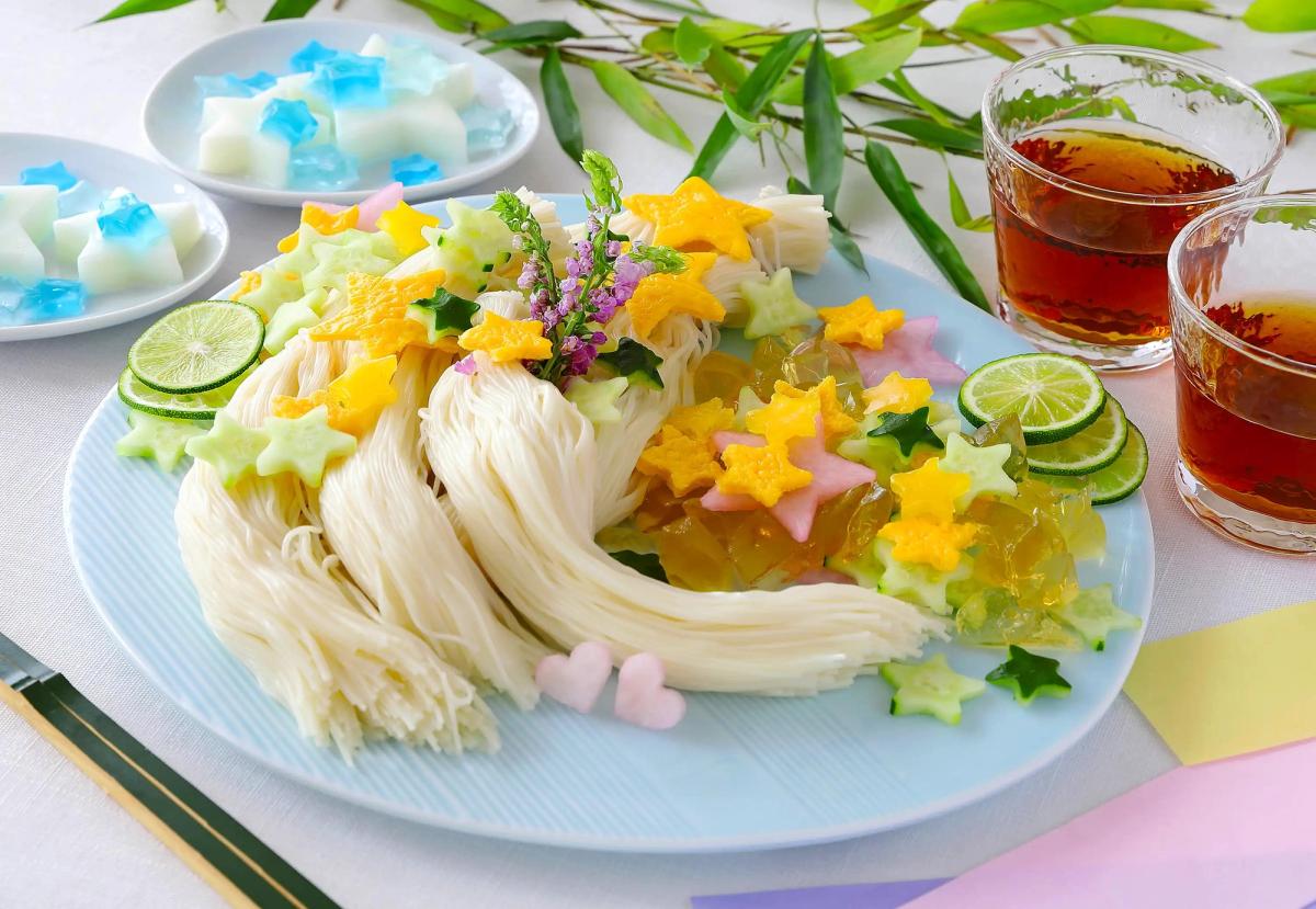 Colorful Vietnamese pho noodles with star-shaped vegetables, fresh herbs, lime, and iced tea