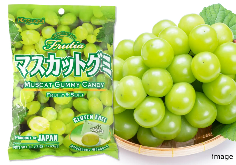 Kasugai Muscat Gummy Candy package next to fresh green muscat grapes