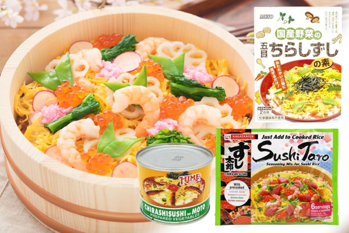Chirashi sushi bowl with shrimp, eggs, and vegetables in wooden container with seasoning packets