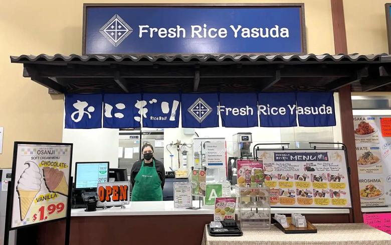 Fresh Rice Yasuda Japanese restaurant counter with staff member, menu board, and soft serve ice cream sign