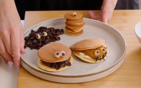 Creative pancake art with chocolate spread and candy eyes arranged on beige plate