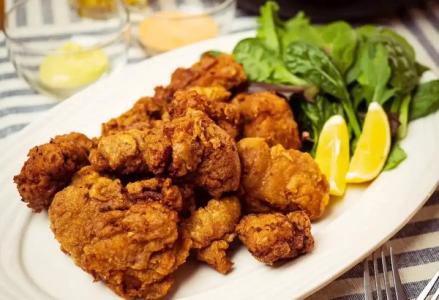 Fried chicken plate with fresh mint, lemon wedges on white dish