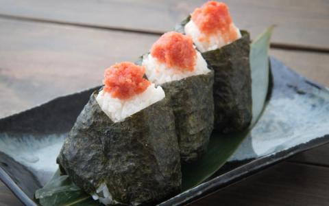 Three nigiri sushi pieces with ikura salmon roe on nori-wrapped rice on ceramic plate
