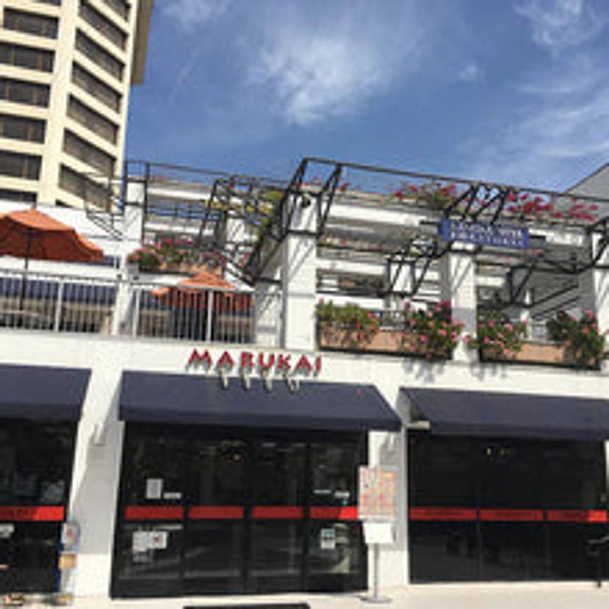 Marukai storefront with red awnings, modern building facade, urban shopping district
