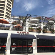 Marukai storefront with red awnings, modern building facade, urban shopping district